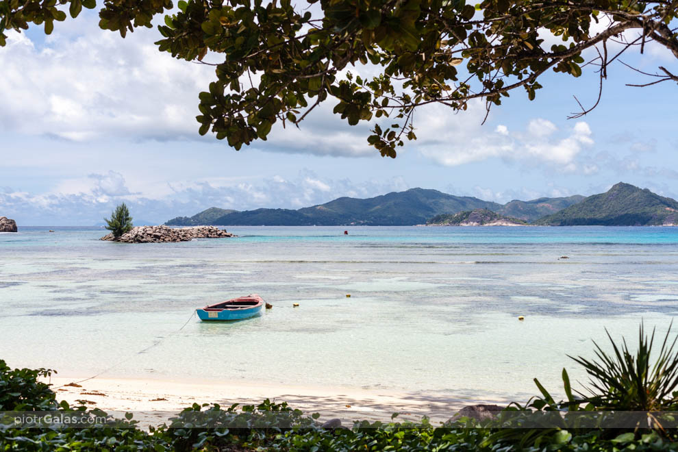 Plaża La Passe z łódką podczas odpływu na La Digue i widok na wyspę Praslin