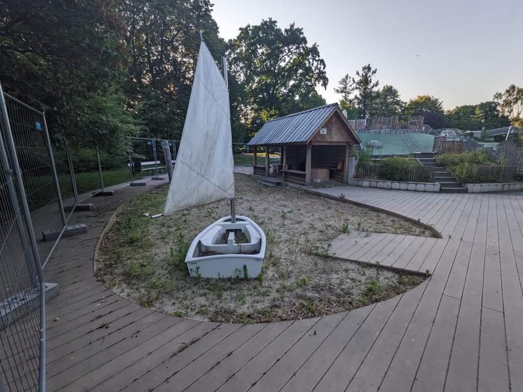Niszczejący plac zabaw w Parku Ujazdowskim - zabawkowa łódka otoczona morzem chwastów