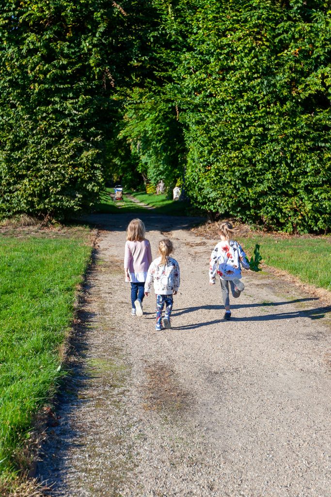 Dzieciaki biegnące parkową aleją